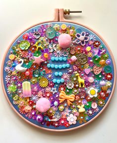 an embroidery project with buttons, beads and other things on the front side of it