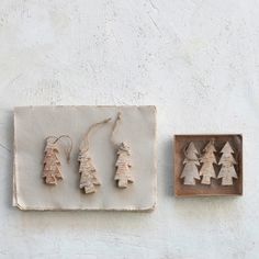 three ornaments are hanging on the wall next to a small wooden box with some string