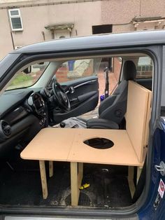 a small table in the back of a car with it's door open and its seat up