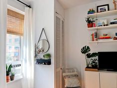 a living room filled with furniture and a flat screen tv sitting on top of a wooden shelf