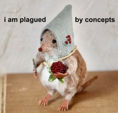 a small toy mouse with a hat on it's head holding a raspberry