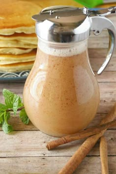 cinnamon cream syrup in a glass pitcher next to pancakes