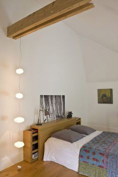 a bed sitting in a bedroom under a wooden beam