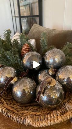 a basket filled with silver ornaments on top of a wooden table