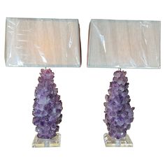 two lamps with purple crystals on them sitting next to each other in front of a white background