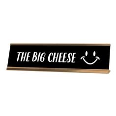 a sign that says the big cheese with a smiley face drawn on it's side