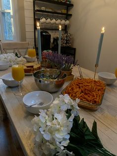 the table is set with plates, bowls and glasses for breakfast or brunch