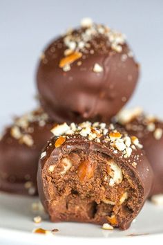 three chocolate balls stacked on top of each other with nuts and pecans in the middle