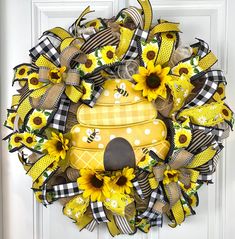 a yellow and black wreath with sunflowers is hanging on the front door,