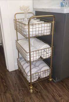 three baskets are stacked on top of each other in the corner of a room with wood flooring