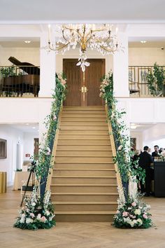 an elegant staircase decorated with flowers and greenery