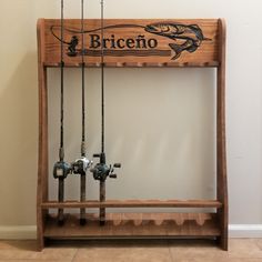 a wooden shelf with fishing rods and reels hanging from it's sides in front of a wall