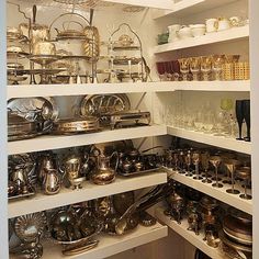 the shelves are filled with many different types of dishes and silverware in various sizes