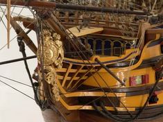 an old model ship with gold decorations on it