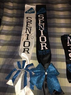 three ribbons with the words senior and mom on them are laying on a plaid blanket