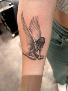 a woman's arm with a tattoo on it that has a bird flying over her head