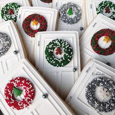 christmas wreaths are displayed in white boxes with bead designs on them and green leaves