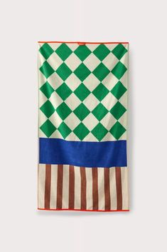 a green, white and blue checkered towel hanging on a wall with an orange border