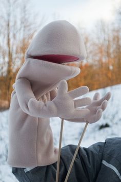 a person wearing a puppet like head and hands with one hand on top of the other