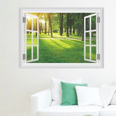 an open window with the sun shining through it in front of a green field and trees