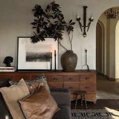 a living room filled with furniture and a potted plant on top of a table