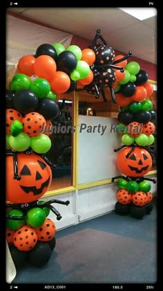 an entrance decorated with balloons and pumpkins for halloween party decorations in orange, black and green colors