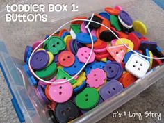 a plastic container filled with lots of colorful buttons