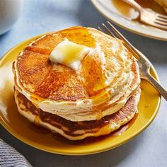 pancakes with butter and syrup on a yellow plate