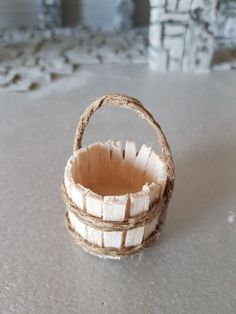 a small basket sitting on top of a cement floor next to a wall and window