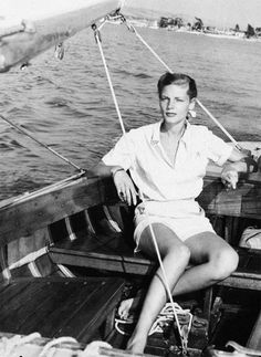 a black and white photo of a woman on a boat