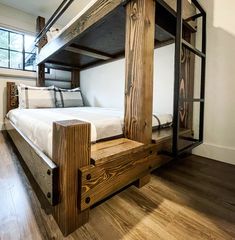 a bunk bed made out of wooden planks in a room with hard wood flooring