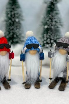 three gnomes with ski poles and hats in the snow