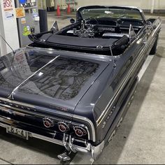 an old car is parked in a garage with the hood up and it's hood down