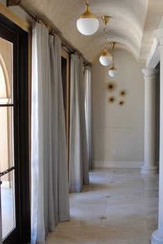 the hallway is lined with white curtains and light fixtures