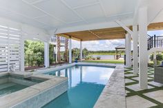 an outdoor swimming pool surrounded by white pillars