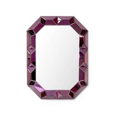 a pink diamond shaped mirror sitting on top of a white wall