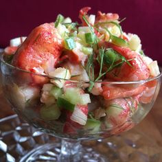 a glass bowl filled with lobster and vegetables