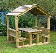 a wooden picnic table and bench in the grass