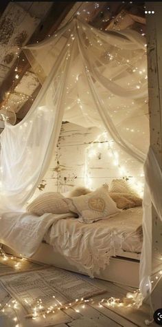 a bed with white sheets and lights around it