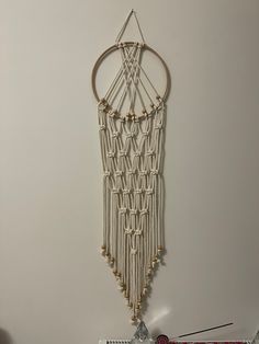 a macrame hanging on the wall with beads