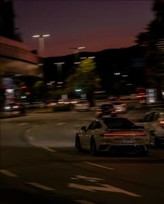 two cars driving down the street at night