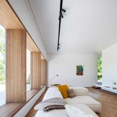 an image of a living room with white furniture and wood flooring on the walls