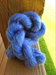 a skein of blue yarn sitting on top of a wooden bench