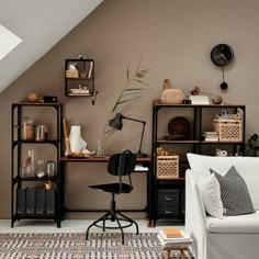 a living room filled with furniture and a clock on the wall above it's desk