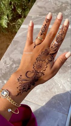 a woman's hand with henna tattoos on it