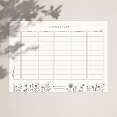 a blank planner with flowers and plants on the side, next to a potted plant