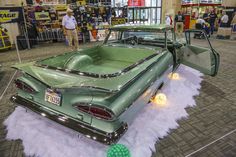 an old green car is on display in a showroom