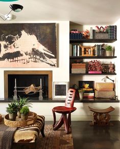 a living room filled with lots of furniture and bookshelves next to a fire place