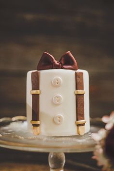 a white cake with brown bow and buttons on it