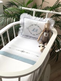 a stuffed animal sitting on top of a white bed next to a pillow and blanket